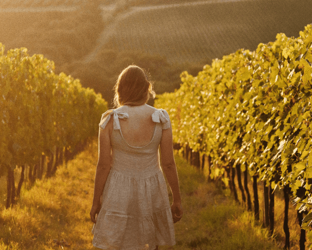 A women walking through a vineyard.