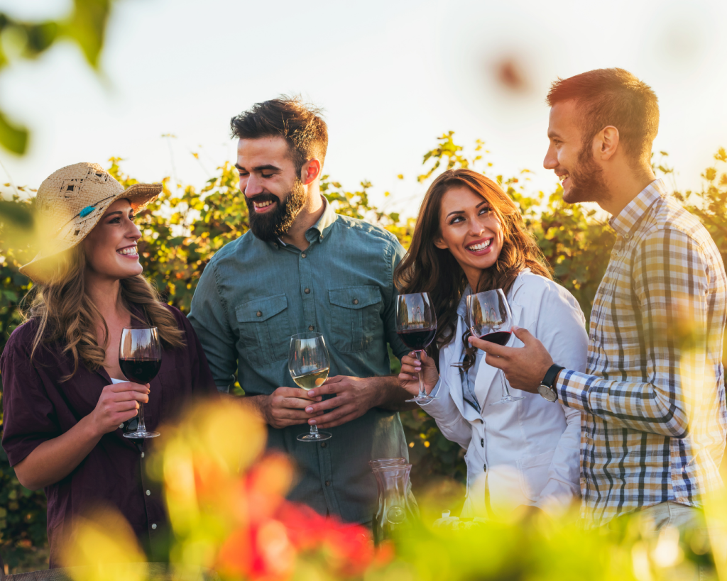 A group of friends standing outside drinking wine