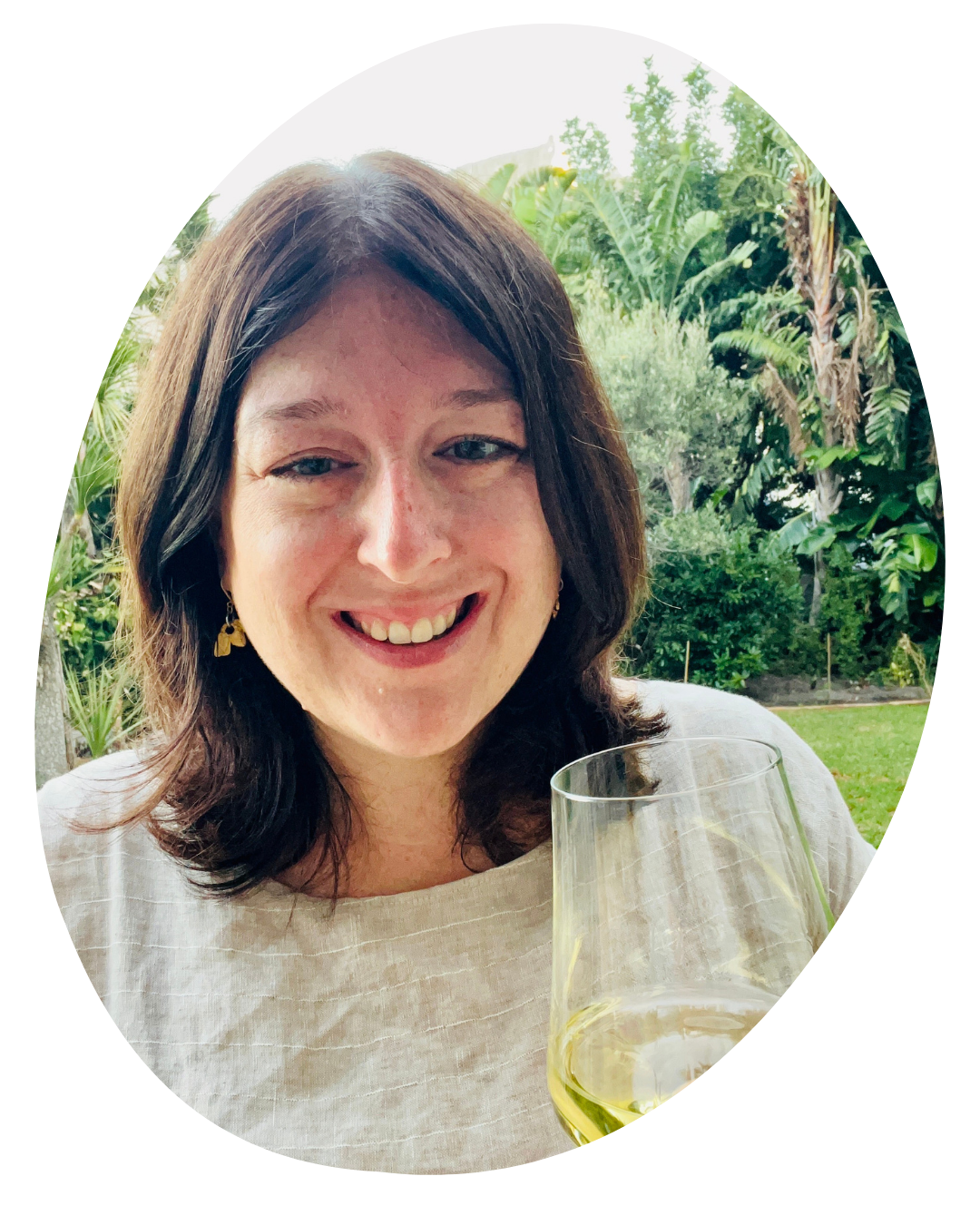 Kathryn Bowen holding a glass of white wine.
